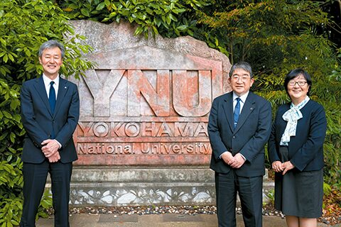 横浜国立大学の記念碑の前で集合写真